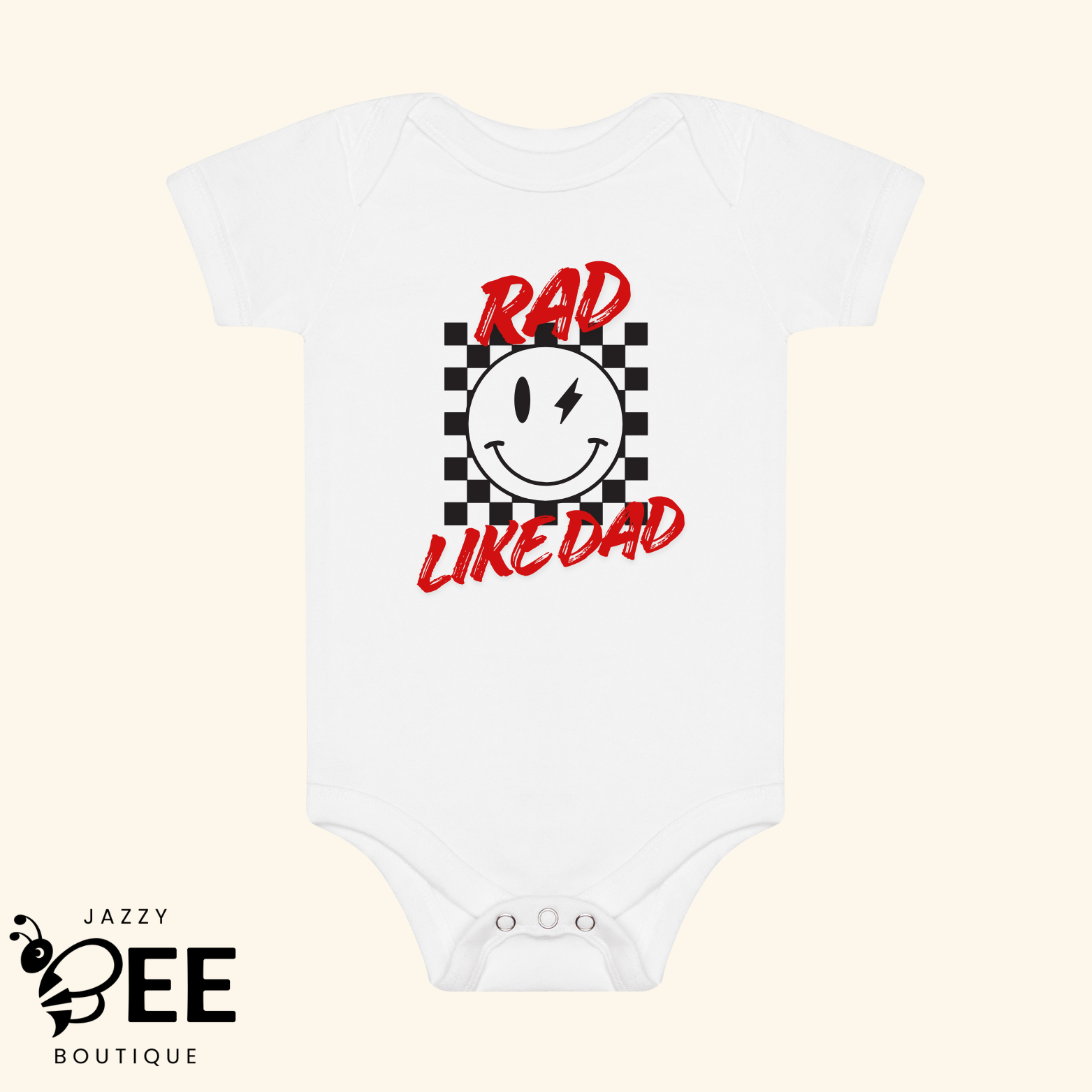 White baby onesie with a smiley face and text on a beige background, featuring the brand 'Jazzy Bee Boutique'.